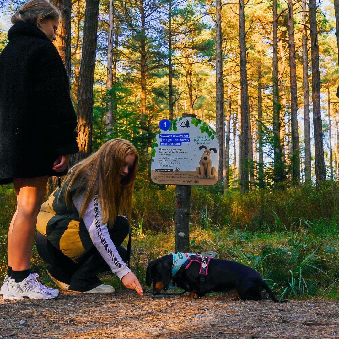 girls with sausage dog at trail sign.jpg